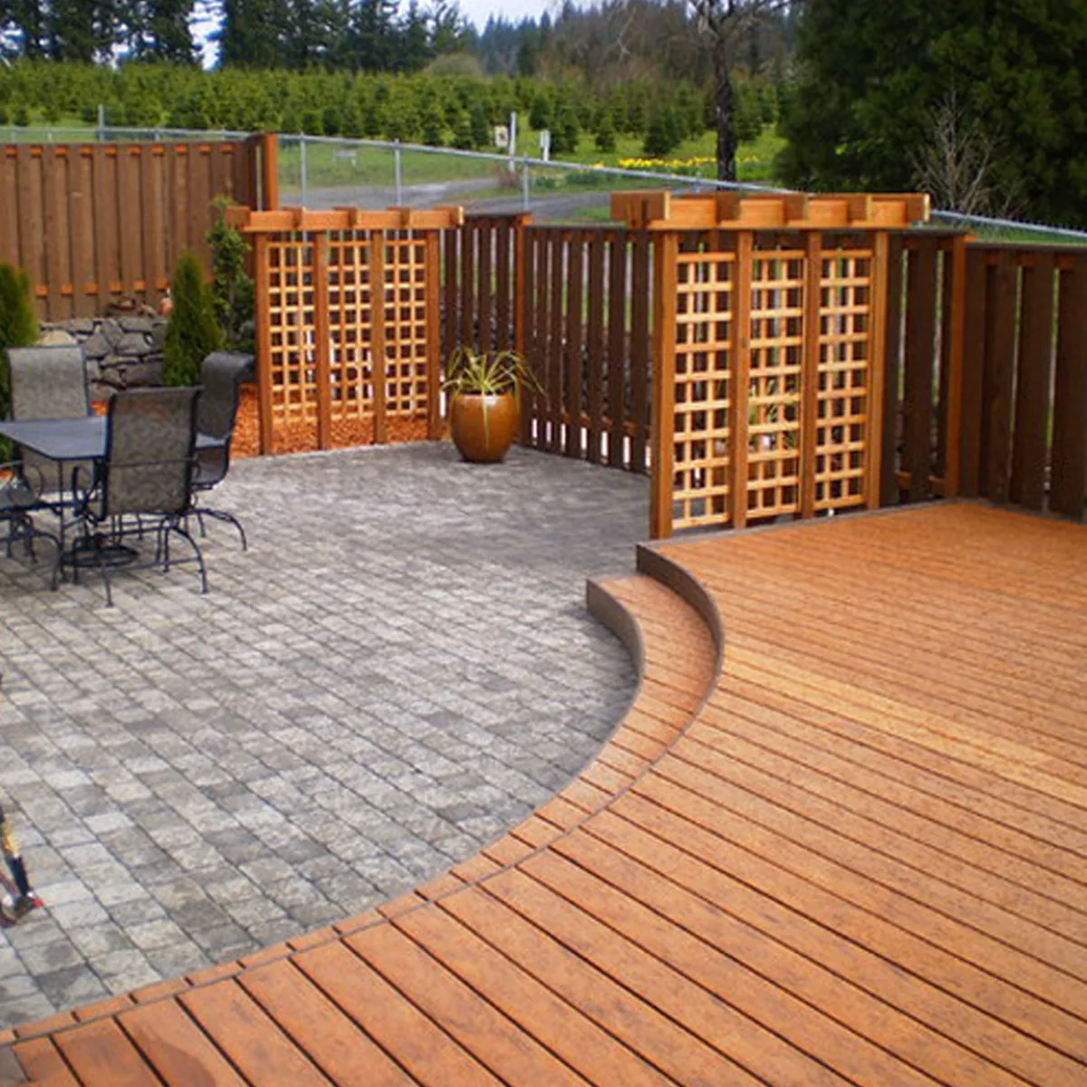 Landscaped patio with curved deck and fencing
